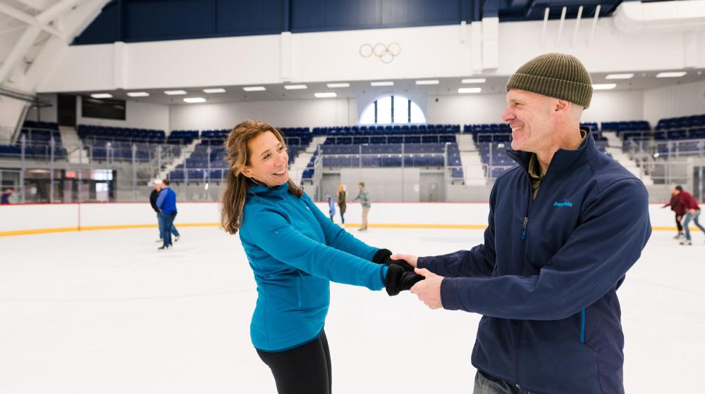 A man and woman ice skate together.